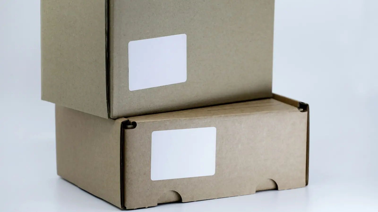 Two shipping boxes stacked on a white table